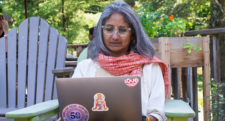 Woman sits on cafe desk with laptop