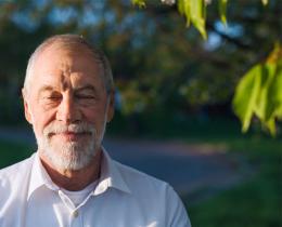 Peaceful older man smiling with eyes closed practicing mindfulness, self-compassion, and lovingkindness meditation as part of daily wellness and emotional resilience.