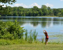 Person stretching on the lake shore