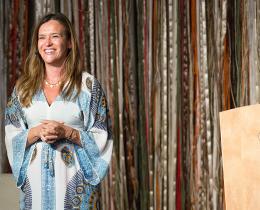 Robyn Moreno smiling on stage, sharing her story of healing, Curanderismo, and ancestral wisdom from her book Get Rooted.