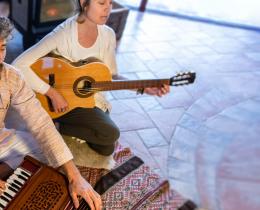 Man and woman playing guitar and harmonium