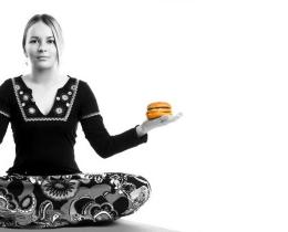 Woman with an apple in one hand and a hamburger in the other