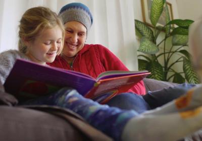 Woman & child reading a book together