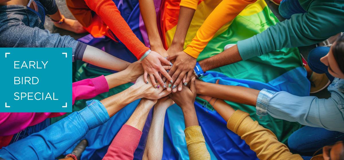 Group of people in different color shirts forming a rainbow.