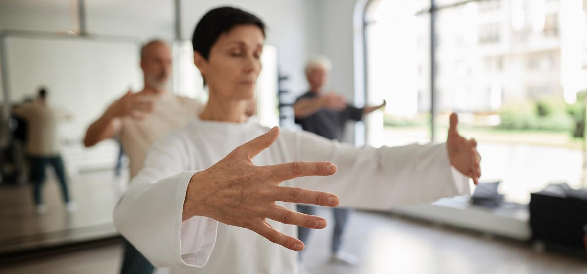 Woman in a simple qigong pose in a classroom