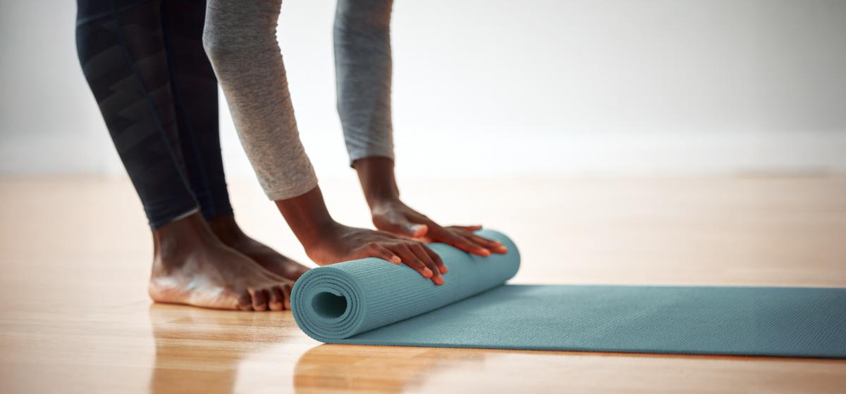 Black woman rolling up her yoga mat