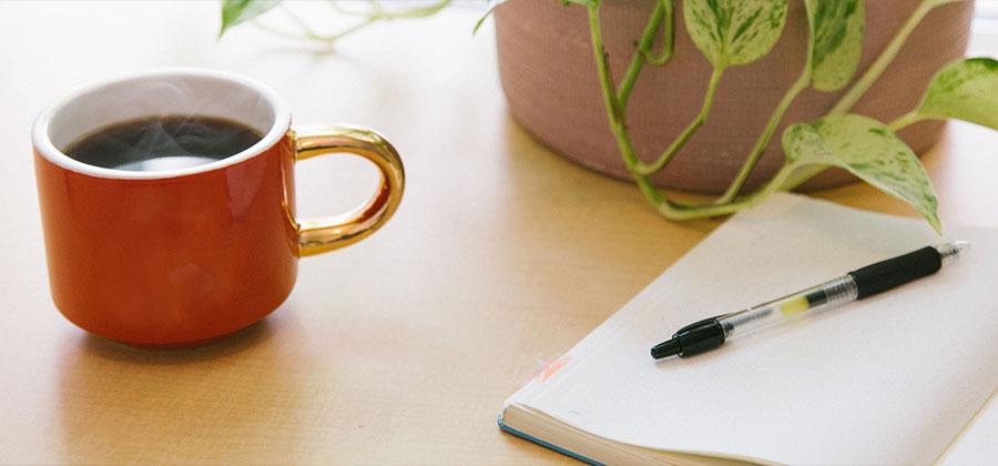 Cup of coffee and a notebook on a desk