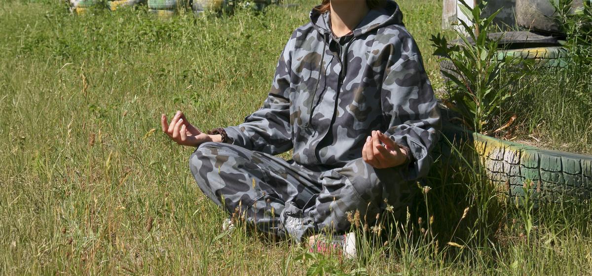 Woman meditating in a grassy field