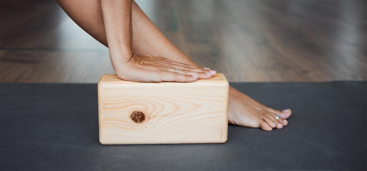 Person in yoga pose using a yoga block