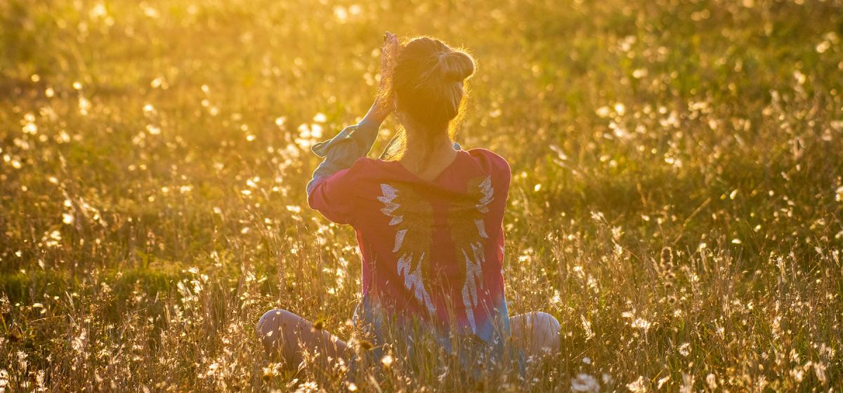 woman meditating in a field