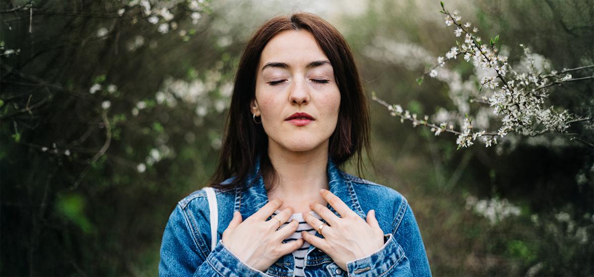 Woman doing somatic breathwork in the woods