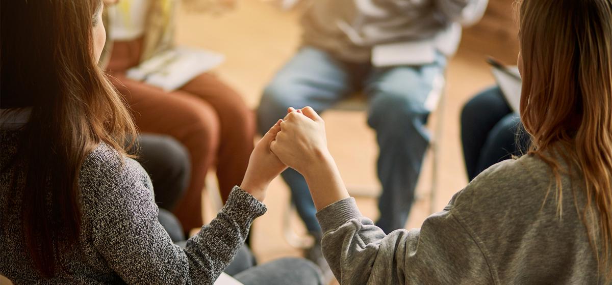 People holding hands in circle in group session