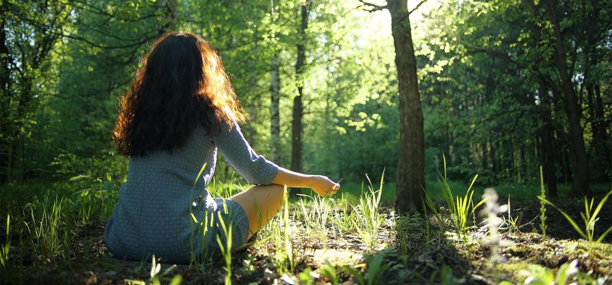 Woman meditating in a forest