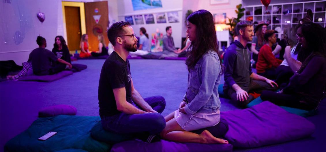 Couple engaged in yoga pose looking at each other