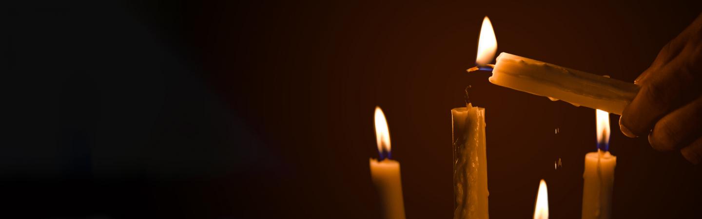 Lighting candles in darkness symbolizing feminine spirituality and sacred texts in the Mary Magdalene Gospel.