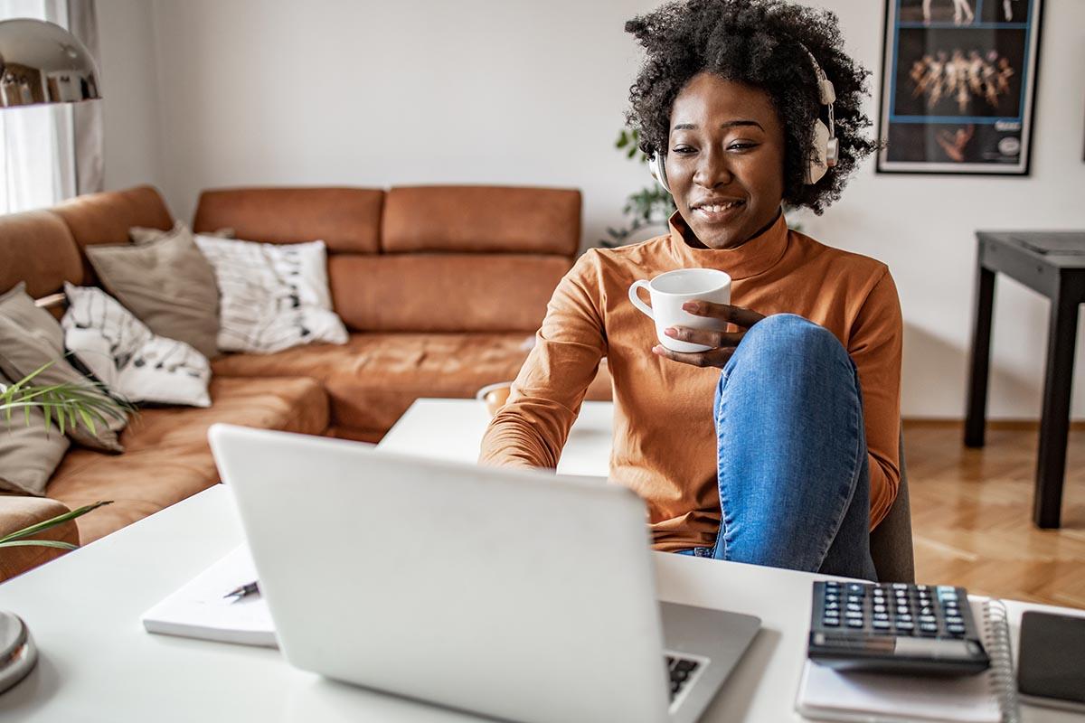 Woman at desk with coffee cup and laptop